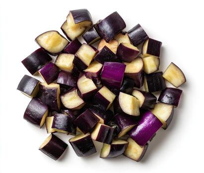 Overhead view of chopped eggplant cubes in various sizes, against a clean white background photo
