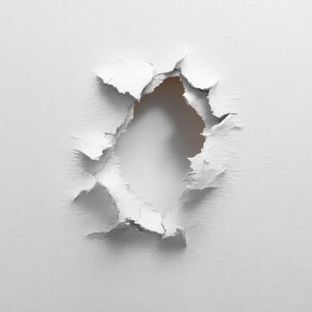 A hole punched through white paper, radiating cracks photo