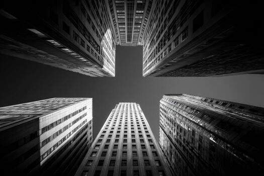 Black and white, low-angle view of skyscrapers reaching to the sky, forming a symmetrical pattern photo