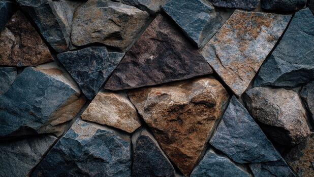 de cerca ver de un Roca pared construido con varios tamaño y conformado piedras en sombras de gris, marrón, y gris pardo foto