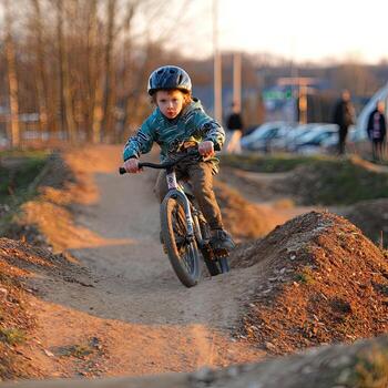 Young biker navigating a dirt jump track photo