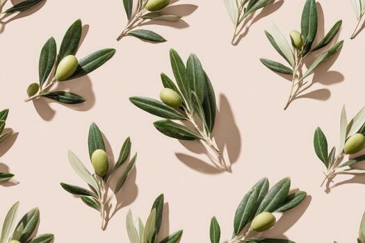 Overhead shot of olive branches with green olives, arranged on a light-pink background photo