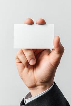 A hand holds a blank business card against a solid white background, showcasing detail photo