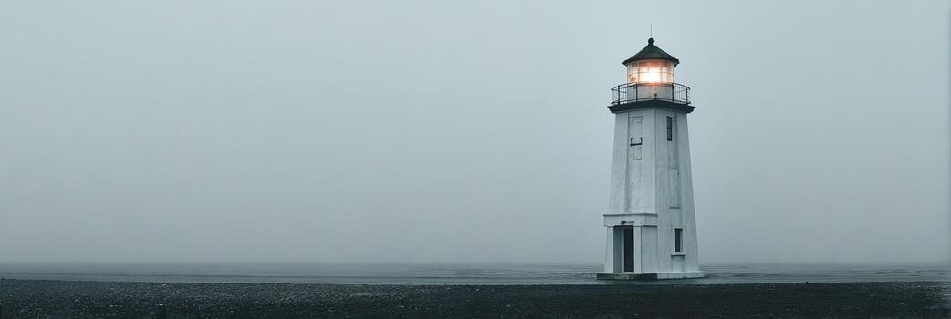 A tall, white lighthouse stands with its light illuminated on a foggy coast photo