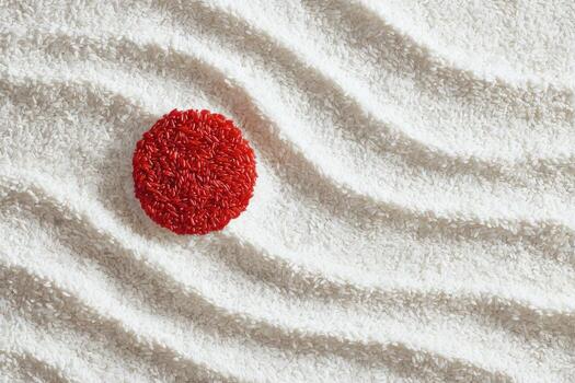 un rojo, texturizado circulo descansa en rastrillado blanco material con fluido ola patrones foto