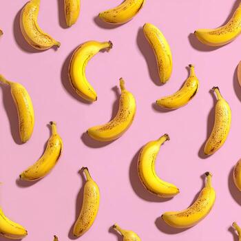Scattered arrangement of ripe bananas with shadows on a pastel pink background photo