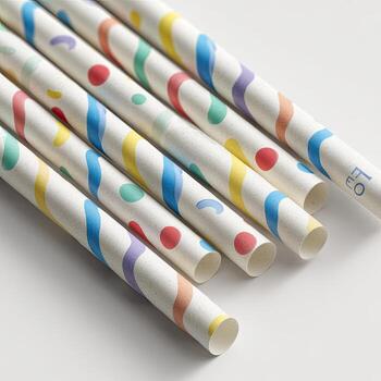 Angled close-up of patterned paper straws. White background. Colorful stripes, dots, and shapes photo