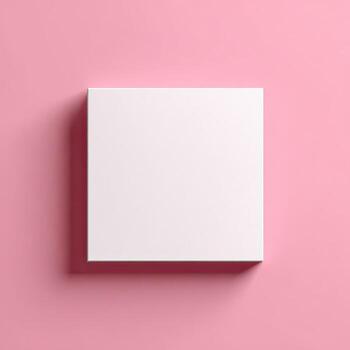 A top-down view of a square, white box casting a shadow on a smooth, pink surface photo