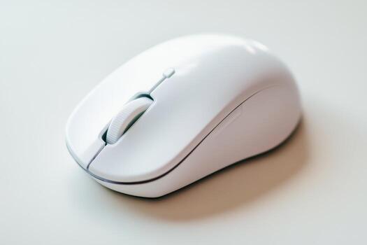 White wireless computer mouse cutout on a light background. Top view. Simple, compact, portable mouse with copy space. Modern design and technology. Slim optical mobile Mouse for laptop, PC, tablet. photo
