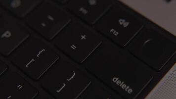 fechar-se do excluir chave em moderno Preto computador portátil teclado, simbolizando apagar, remover, dados ao controle, digital segurança, escritório trabalhos e tecnologia detalhe video