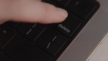 dito urgente Elimina chiave su il computer portatile tastiera del computer, concetto di cancellando, rimozione File, dati protezione, in linea sicurezza, attività commerciale decisione e digitale controllo video