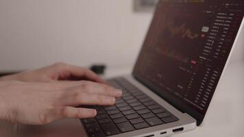 händer skriver på bärbar dator tangentbord med kryptovaluta handel plattform öppna, som visar ljusstake diagram, röd tal, och realtid marknadsföra data för uppkopplad investering och analys video
