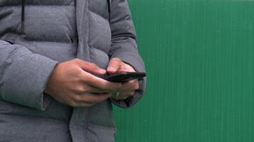 närbild av person använder sig av smartphone, händer interagera med skärm, textning eller bläddring video