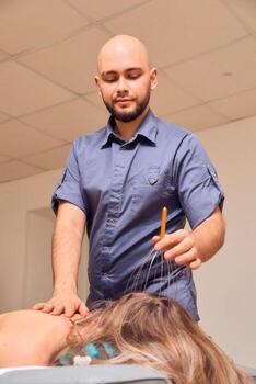 Engaging in a Therapeutic Session Utilizing Acupuncture Techniques in Practical Application photo