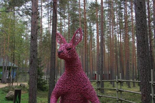 a kangaroo head made of colored twigs against the background of trees, photo