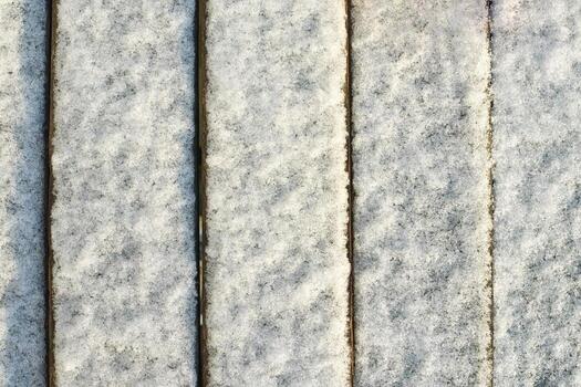 Close-up of frost-covered wood panels in parallel lines demonstrating winter texture and natural patterns. photo