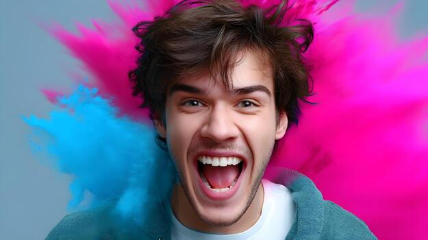 Joyful young man laughing with colorful paint splash explosion photo
