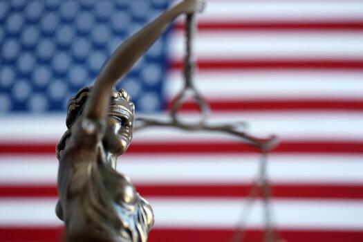 The statue of justice is in front of the american flag photo