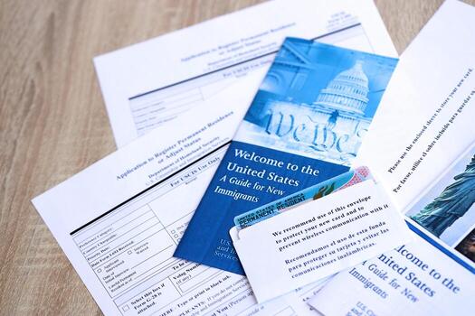 Permanent resident green card in envelope with application and guide for new immigrants lies on table photo