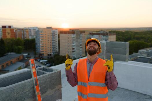Construction worker pointing upwards at building site with cranes photo