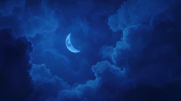 A crescent moon peeks through dark clouds photo