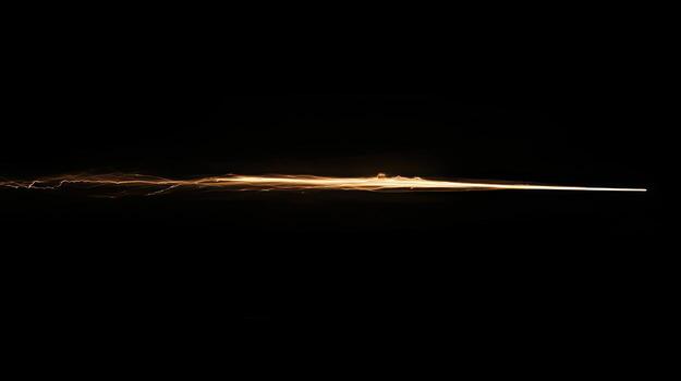 A horizontal, glowing streak of light against a black background photo