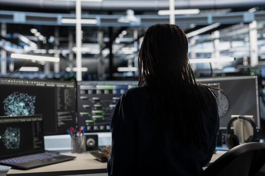 Data center technician uses AI visualization tool on computer to oversee automated repetitive tasks. Worker adapting server systems based on data analytics graphs using desktop PC photo