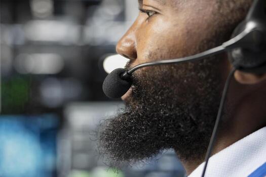 Close up of employee in server farm talking in mic, coordinating technicians. Data center support specialist supporting engineering team doing hardware maintenance, speaking in microphone photo