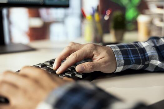 Close up shot of remote worker at home office desk using computer, typing on keyboard, editing documents. Freelancer in apartment using PC to complete spreadsheets, solving tasks photo