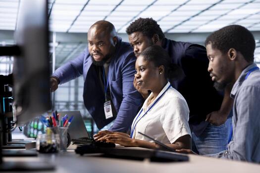 Team of engineers reconfiguring server farm to optimize it for data processing requirements of customers. Coworkers collaborating to ensure data center equipment operates efficiently photo