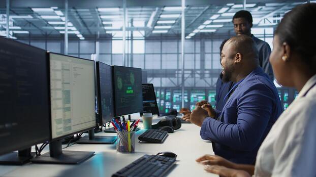 Happy data center employee pleased after successfully installing cybersecurity framework, seeing confirmation after reducing security incidents and enhancing data protection protocols, camera A photo