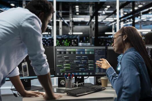 Manager supervising technician programming in server farm housing infrastructure storing datasets. Team leader overseeing IT expert coding, repairing data center racks doing computational operations photo