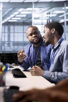 Data center admin discussing with coworker, using programming languages to construct algorithms and build applications. Server hub IT specialist talking with colleague, debugging and optimizing code photo