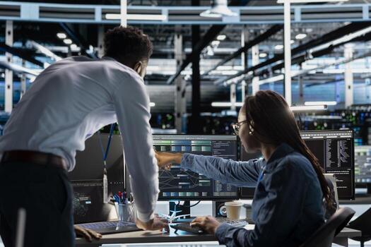 Data center team leader supervising technician setting up machine learning systems handling information. Supervisor oversees employee training neural networks to improve server farm operations photo