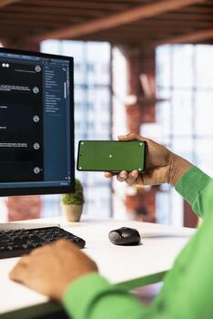 Man watching tutorial on chroma key smartphone to learn how to solve tasks with AI chatbot. Close up of person looking at guides on isolated screen mobile phone about LLM assistants photo