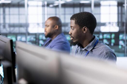 Team of technicians in data center workspace running system diagnostic tests and error checking utilities to fix problems. Coworkers looking for network issues affecting rigs performance photo