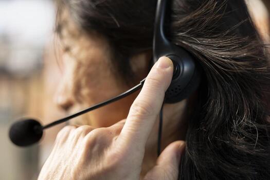 Call center agent talking in headset mic, using remote access tools to connect to customer devices. Customer center worker assisting clients with installation using headphones microphones, closeup photo