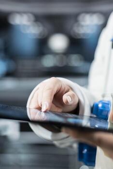 Close up of astronaut checking orbital navigation data on tablet to ensure safe operation during long distance space travel. Orbital station crew member runs telemetry software during cosmic journey photo