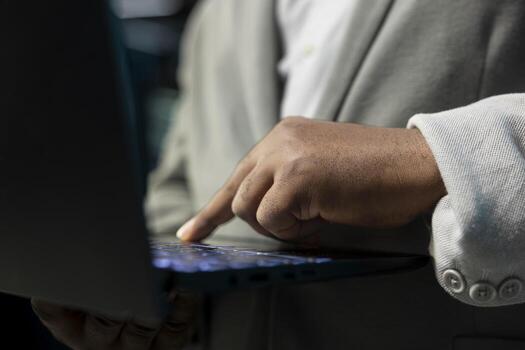 Close up of programmer in data center typing on notebook keyboard, writing lines of code. Server room IT expert using programming scripts on laptop, running diagnostics on infrastructure photo