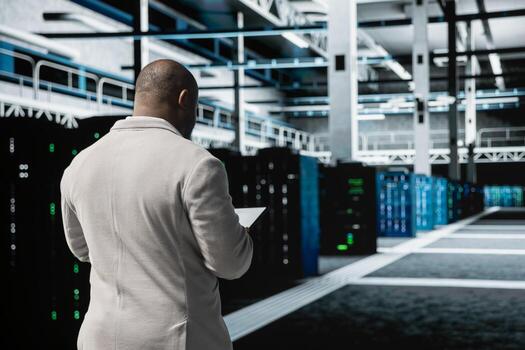 Technician in data center workspace running system diagnostic tests, increasing uptime and efficiency. Employee looking for network issues affecting rigs performance, installing upgraded server racks photo