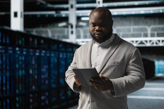 Data center employee fixing network issues affecting rigs performance, scripting automated workflows. Technician running system diagnostic tests, evaluating reports on tablet photo