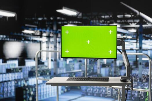 Mockup computer in high tech industrial data center used for AI system monitoring and performance tracking. Green screen PC overseeing server cabinets involved in computing operations. photo
