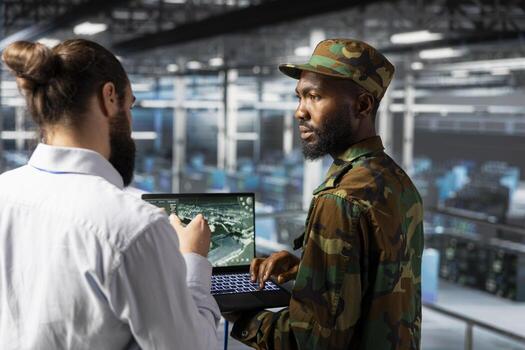 Military technician in data center monitoring warfare drone imagery in server farm command center. IT specialist in army server room using tactical interface to support aerial operations. photo