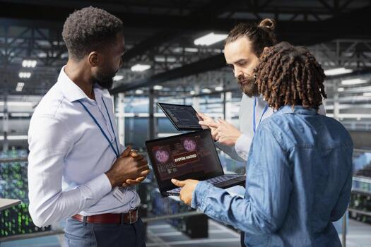 Multiethnic team worrying about compromised systems due to security breach, implementing emergency protocol to protect and save the server hub infrastructure. Malicious hacking danger. photo