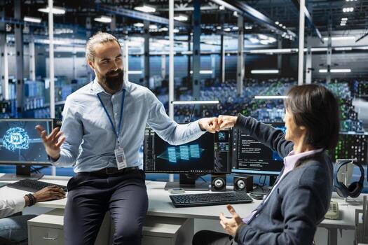 Coworkers coding in data center doing fist bump, pleased after updating AI automation scripts. Happy server room colleagues celebrating programming artificial intelligence algorithms photo