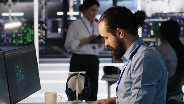 Server hub worker arranging desk objects to optimize efficiency during tasks. Data center system administrator reorganizing desk items to streamline workflow and boost productivity photo
