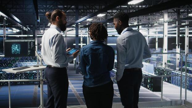 Software developers in data center monitoring AI LLM visualization. Server farm teamworking colleagues doing brainstorming, overseeing rigs powering machine learning processes, photo