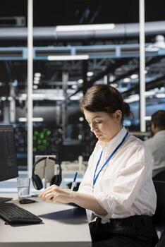 Server room worker holding clipboard, following procedures to evaluate system performance metrics. Woman in data center going over maintenance fixes list, running diagnostics on equipment. photo
