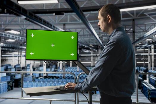 Server farm IT expert uses mockup computer, debugging software issues and improving system stability. Data center technician using green screen PC monitor, monitoring hardware for potential failures photo