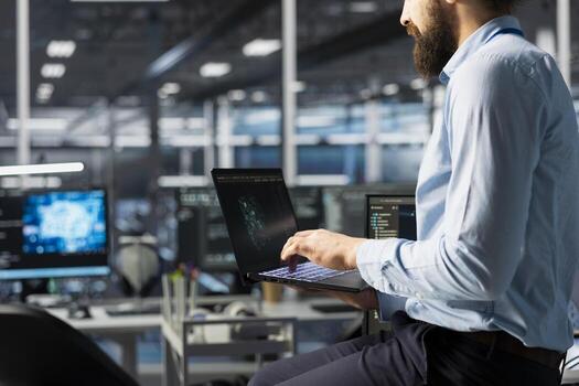 Programmer coding in high tech data center office, updating AI automation scripts. Server room employee programming artificial intelligence algorithms, debugging equipment racks photo